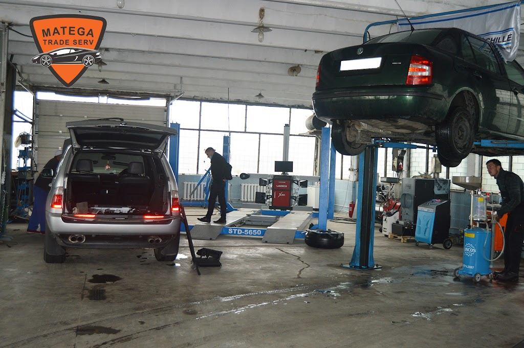 Interiorul atelierului Matega Service Auto, cu două lifturi hidraulice și mașini în lucru