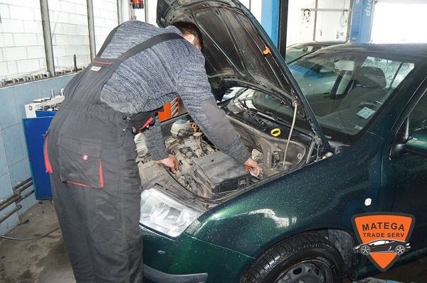 Mecanic Matega verificând motorul unei mașini pe elevator